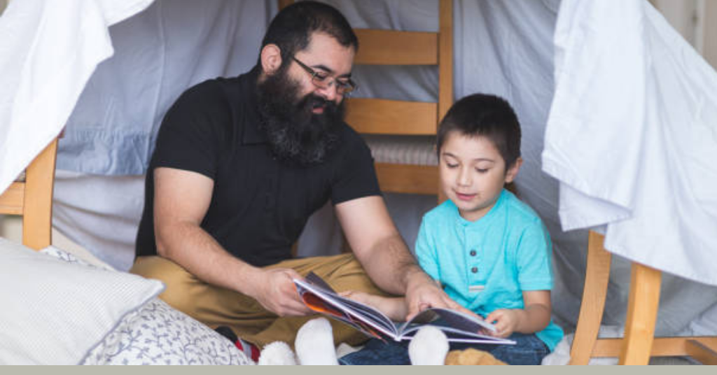 a child and father reading a book together