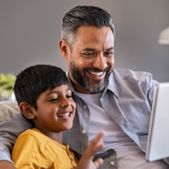 A child and father using a tablet