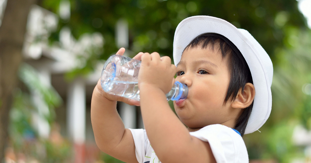 small boy drinking water