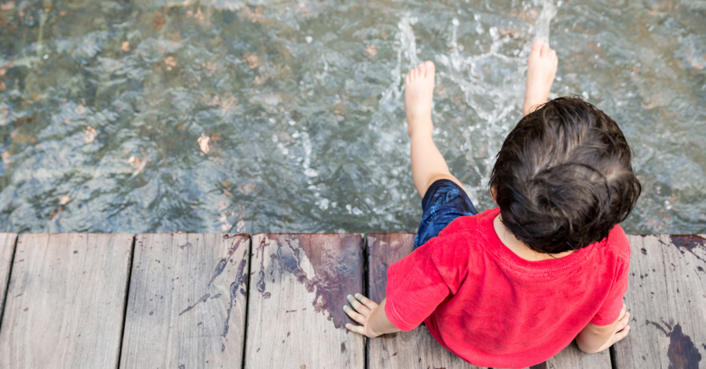 boy dipping his feet in water