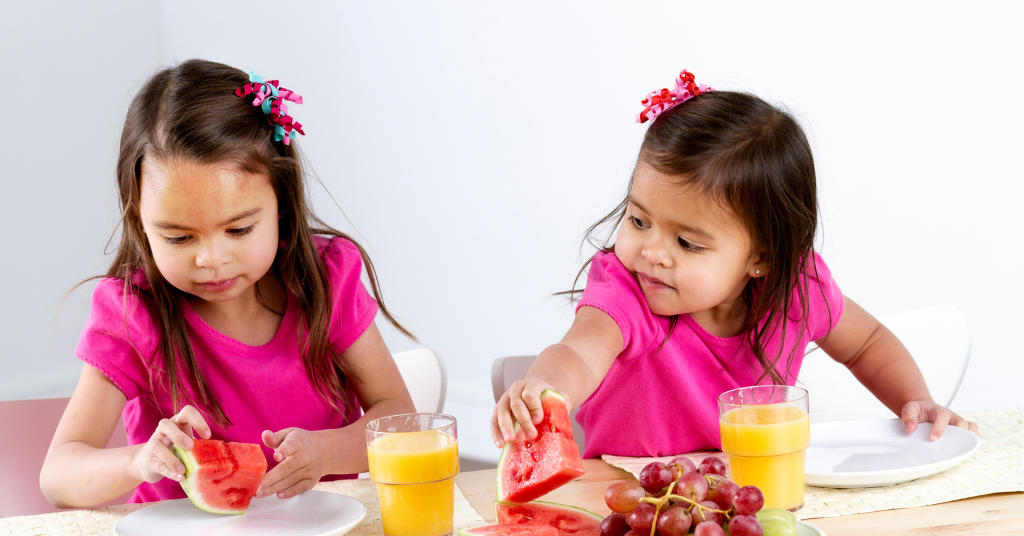 2 girls eating fruits