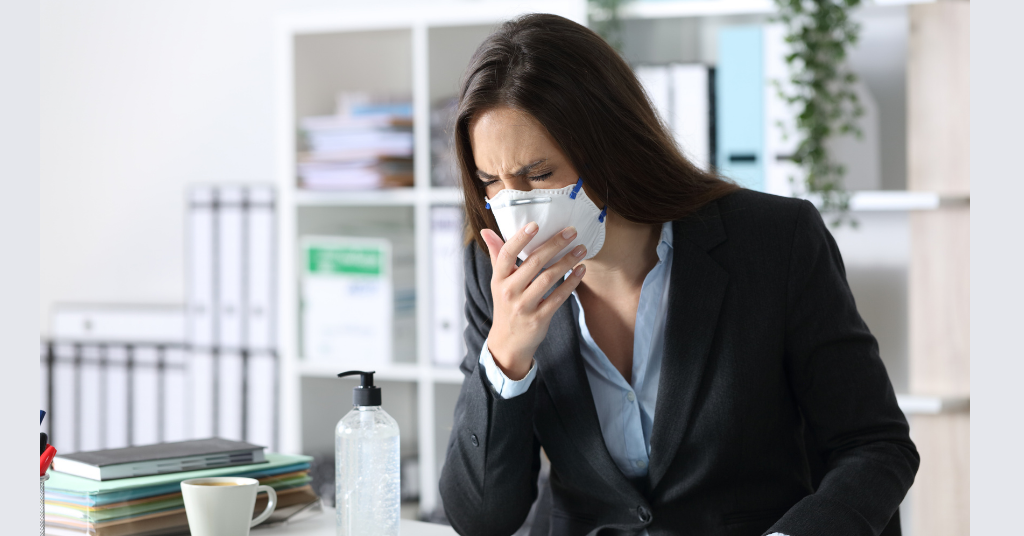 woman sneezing in mask