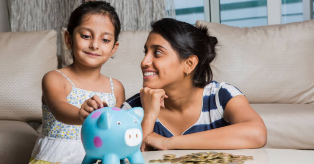 child putting money in piggy bank